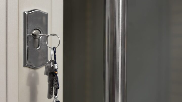 A bunch of keys left hanging in the cylinder of an apartment door