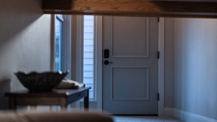Interior side of an electronic deadbolt on a rental entry door at dusk