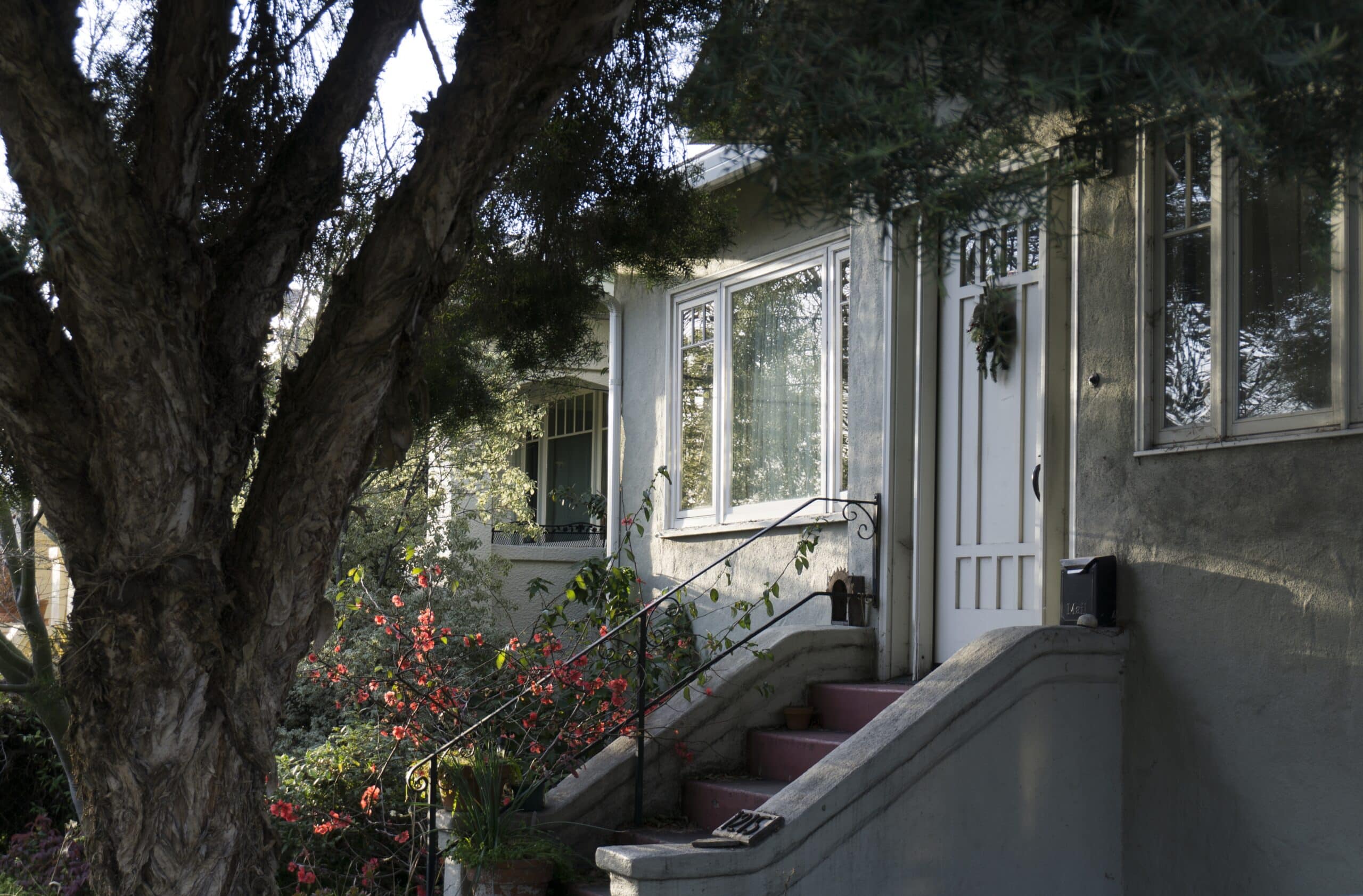 A white front door with a staircase and a small black mailbox mounted beside it.